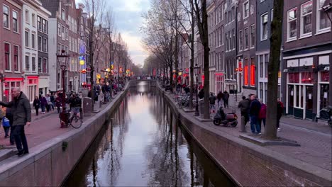 Toma-Panorámica-De-Una-Multitud-Caminando-Por-El-Barrio-Rojo-De-Wallen-En-Amsterdam-Por-La-Noche