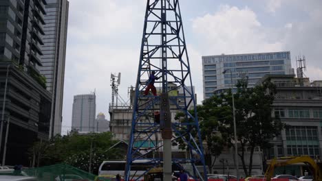 Construction-worker-fixing-cabling-on-a-crane-in-Bangkok,-Thailand
