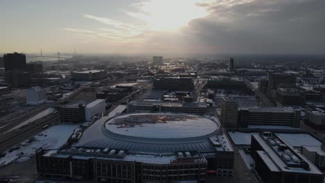 Little-Caesars-basketball-arena-and-downtown-of-Detroit-with-storm-clouds-above,-aerial-view