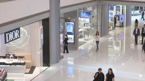 Chinese-shoppers-walk-past-the-French-high-end-fashion-brand-Dior-store-at-a-shopping-mall