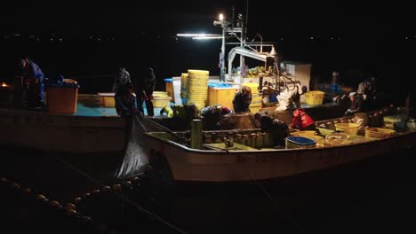 Japanese-Firefly-Squid-Fishermen-on-Boats-in-Night,-Bringing-in-Catch