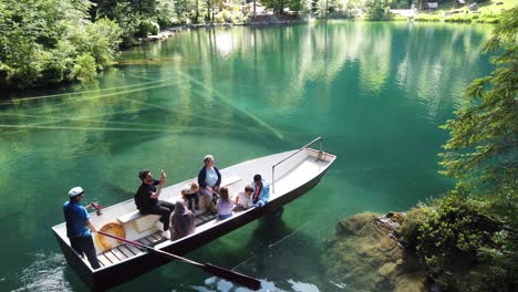 Multiethnische-Touristenfamilien-Genießen-Eine-Fahrt-Mit-Einem-Glasboden-Quellenboot-Auf-Dem-Kristallklaren-Türkisfarbenen-Wasser-Des-Berühmten-Alpensees-Blausee-In-Kandersteg,-Schweiz