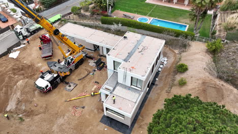 Construction-site-of-luxury-house-with-industrial-crane,-aerial-drone-view
