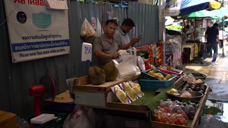 Obstverkäufer-Verpacken-Früchte,-Während-Sie-Auf-Dem-Lokalen-Markt-In-Silom-Soi-10,-Bangkok,-Thailand,-Auf-Kunden-Warten