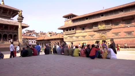 Static-Shot-of-People-Seatting-in-Front-of-a-Temple-in-Patan-Kathamdu-during-a-sunny-Day-Nepal