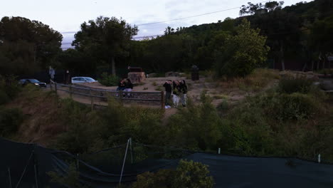 Aerial-view-around-people-at-a-viewpoint,-evening-in-Hollywood-hills,-LA,-USA