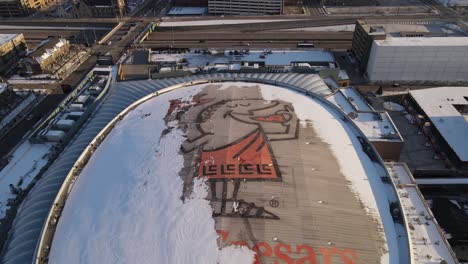 Little-Caesars-basketball-arena-rooftop-covered-with-snow-in-winter-season,-aerial-view