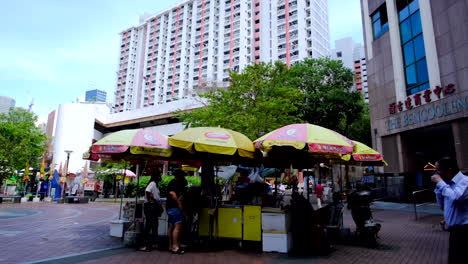 Mini-store-set-up-with-just-umbrellas-and-a-counter-top-in-front-of-the-tall-building-in-Singapore