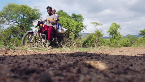 Zwei-Männer-Auf-Einem-Fahrrad,-Die-Auf-Einer-Unbefestigten-Straße-In-Der-Afrikanischen-Savanne-In-Der-Region-Omo-Valley-In-Äthiopien-Vorbeifahren