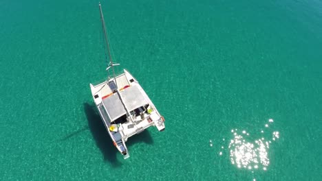 Wide-shot-track-around-catamaran-on-beautiful-clear-green-ocean