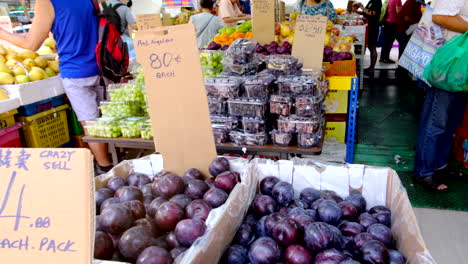 Gente-Comprando-Frutas-En-Los-Puestos-De-Frutas-De-Singapur-Con-Etiqueta-De-Precio-En-Cada-Fruta-Y-Gente.