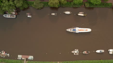 Top-down-aerial-shot-over-Paddle-boat-making-its-way-along-a-murky-river