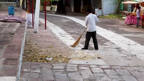 young-man-cleaning-with-broom-at-evening-at-temple-video-is-taken-at-santoshi-mata-mandir-jodhpur-rajasthan-india-on-May-05-2023