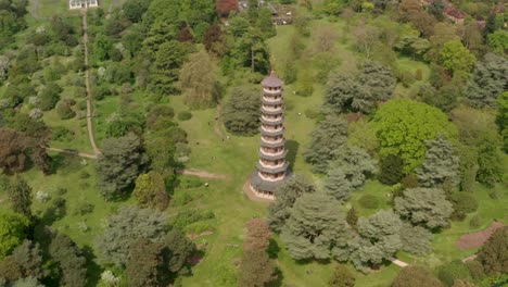 Kreisende-Luftaufnahme-über-Der-Chinesischen-Pagode-Von-Kew-Gardens,-Die-Nach-Oben-Schwenkt,-Um-Den-Rest-Des-Botanischen-Gartens-In-London-Freizugeben
