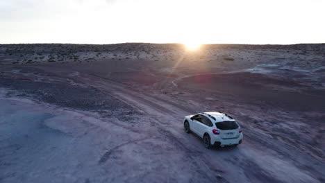 Subaru-Crosstrek-Xv-Blanco-Conduciendo-Fuera-De-La-Carretera-A-Través-Del-Desierto-Vacío-De-Colinas-De-Bentonita-En-Hanksville-Utah-Durante-Una-Vibrante-Puesta-De-Sol