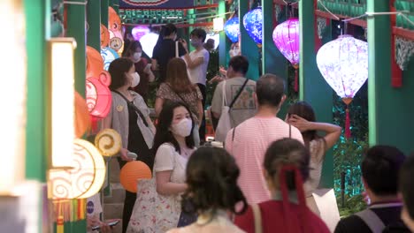 Visitors-pose-and-take-photos-of-lanterns-at-a-lantern-installation-show,-which-symbolizes-prosperity-and-good-fortune,-during-the-Mid-Autumn-Festival,-also-called-Mooncake-Festival
