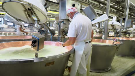 Parmesankäse-Kocht-Bio-Milch,-Molke-Und-Lab-In-Kupferkesseln,-Arbeiter-Rührt-Quark