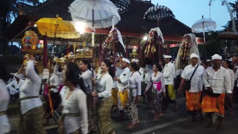 Balinese-Girls-Walk-in-Procession-at-Bali-Temple-Ceremony-Carrying-Barong-and-Mystical-Creatures-such-as-Rangda-and-Umbrellas-at-Night