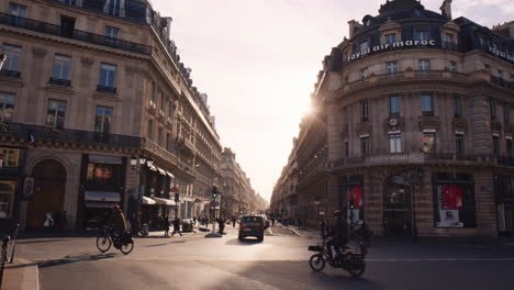 Street-View-of-Paris-Downtown-Commercial-District,-Urban-Bikes-and-Pedestrians-Passing