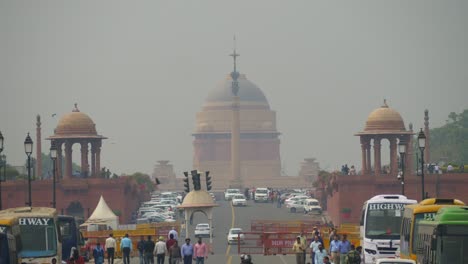 Busy-road-of-Kartavya-Path-during-parliament-session,-people-walking-across-the-street,-New-Delhi-poor-air-quality,-low-visibility,-grey-smog-sky,-India