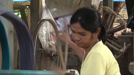 Medium-Shot-Of-Femaile-Traditionally-Spinning-Thread-in-Thailand