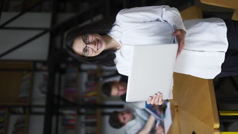 Portrait-smiling-woman-business-student-teacher-in-glasses-science-posing-at-library-desk-laptop-workplace.-Happy-female-in
