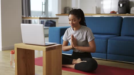 Junge-Afrikanische-Frau,-Die-Yoga-Macht-Und-Vor-Dem-Laptop-Sitzt