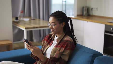Junge-Frau-Benutzt-Smartphone-Zu-Hause-Auf-Einer-Couch
