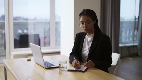 Afro-american-girl-secretary-business-woman-sitting-at-table-at-office