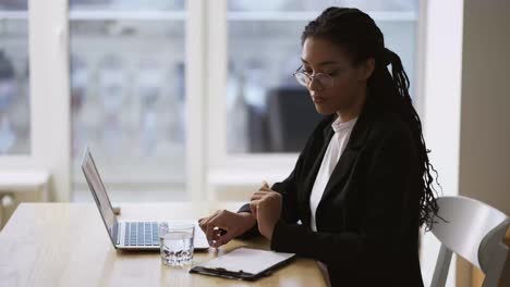 Afroamerikanische-Sekretärin,-Geschäftsfrau,-Die-Am-Tisch-Im-Büro-Sitzt-Und-Einen-Laptop-Benutzt