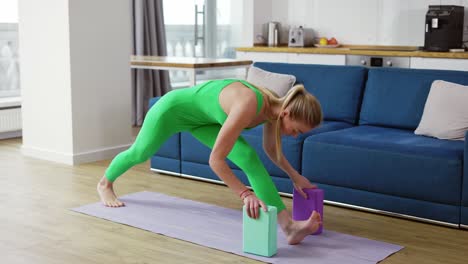 Woman-practicing-yoga-with-yoga-block-in-living-room-at-home