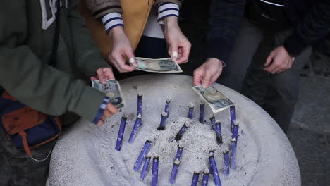 People-drying-yen-notes-over-incense-stick-bowl-at-temple-in-Kamakura-for-good-luck
