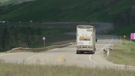 A-semi-truck-drives-by-on-highway-away-from-camera-near-Dunvegan-Alberta