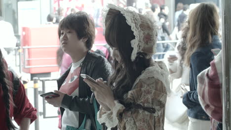 A-young-Asian-woman-dressed-in-a-retro-19th-century-dress-looks-around-in-a-busy-public-space