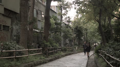 Japanese-female-pupil-walking-on-cobblestone-path-in-Tokyo,-Japan