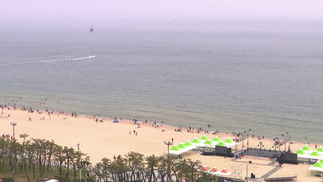 Wide-shot-of-unidentifiable-people-on-the-beach-at-Haeundae-beach,-Busan,-South-Korea