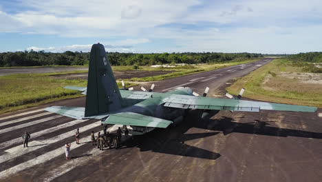 Orbital-aerial-shot-around-the-tail-of-a-big-cargo-plane,-as-soldiers-prepare-to-unload-the-cargo
