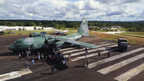 Aerial-shot-as-passengers-exit-from-a-huge-military-cargo-plane-on-a-runway