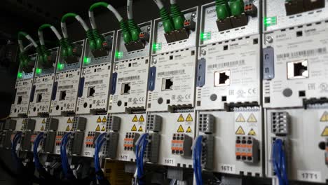 Static-CLOSE-UP-shot-of-a-series-of-industrial-inverter-drives-with-flickering-green-leds-in-a-electrical-cabinet-of-a-running-machine