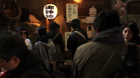 Visitors-offering-coins-and-prayers-at-temple-in-Kamakura