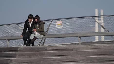 The-young-couple-is-sitting-on-a-bench-at-the-Yokohama-International-Port-Terminal