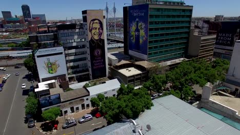 Drone-4k-Sobre-El-Centro-De-Johannesburgo-Con-Imagen-De-Nelson-Mandela-En-Sudáfrica