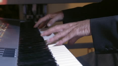 Moving-close-up-shot-of-hands-in-slow-motion-playing-keyboard-on-stage
