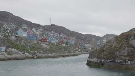 Slowly-Sailing-Past-Inlet-With-Colourful-Houses-On-Rocky-Coastline-In-Greenland