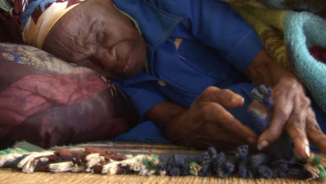 Sick-and-blind-old-african-man-lying-on-bed,-pain-in-face-closeup