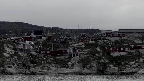 Sailing-Past-Homes-Perched-On-Rocky-Coastline-In-Greenland