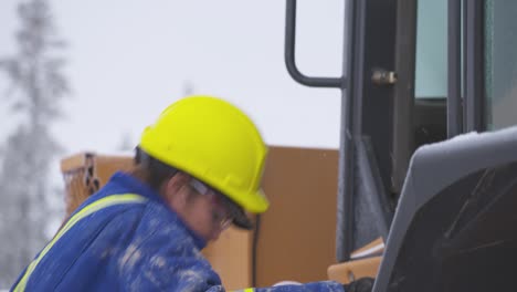 Female-heavy-equipment-operator-performs-thorough-inspection-of-loader-close-up
