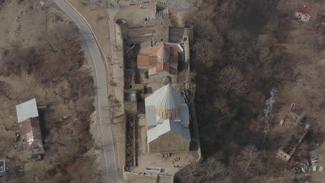Spectacular-overhead-establishing-view-of-Ananuri-fortress-complex,-tilt-down-aerial