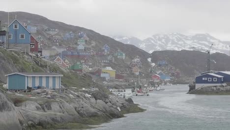 Slowly-Sailing-Past-Inlet-With-Colourful-Houses-On-Rocky-Coastline-In-Greenland