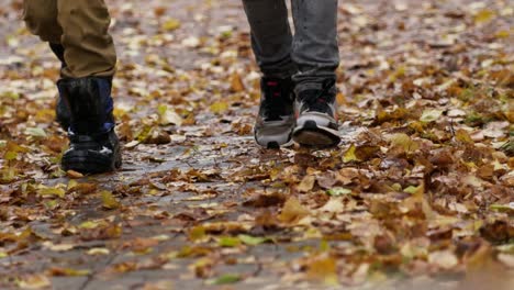 Close-up-of-kids-boots-running-over-wet-leaves-in-the-autumn